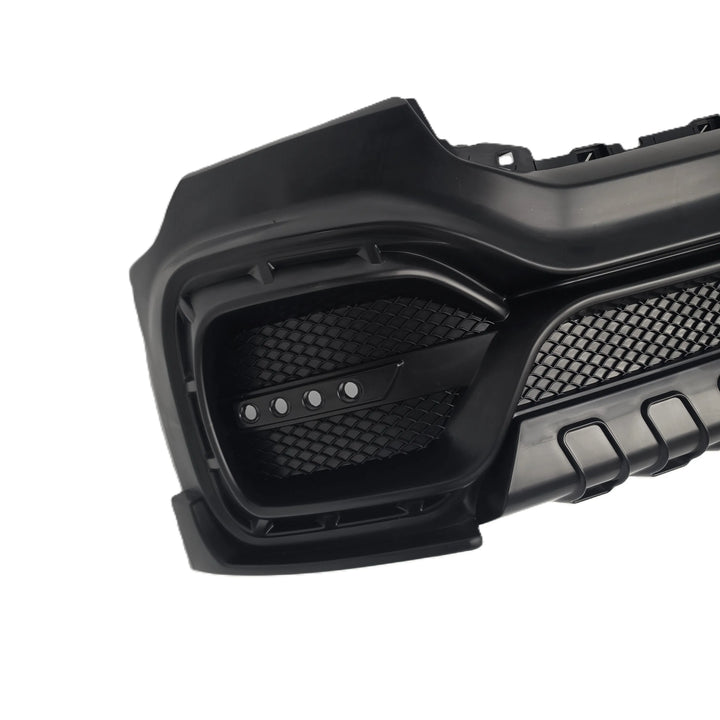 A close-up of a black molded automotive bumper lip or grille component with honeycomb mesh vents and textured plastic surfaces, shown on a plain white background.