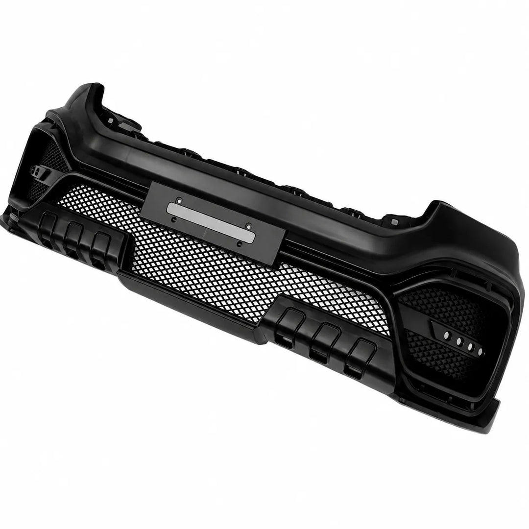 A black plastic front bumper with a honeycomb mesh grille and integrated fog light housings, shown on a plain white background.