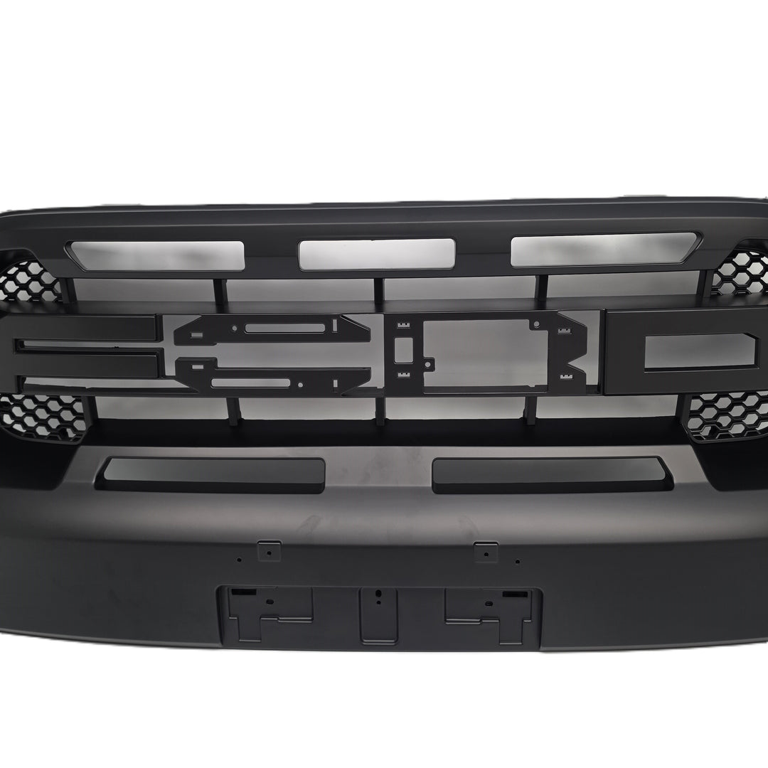 Black metal front grille and bumper assembly for a vehicle, featuring cutouts, mounting brackets, and honeycomb-style mesh details, shown against a plain white background.