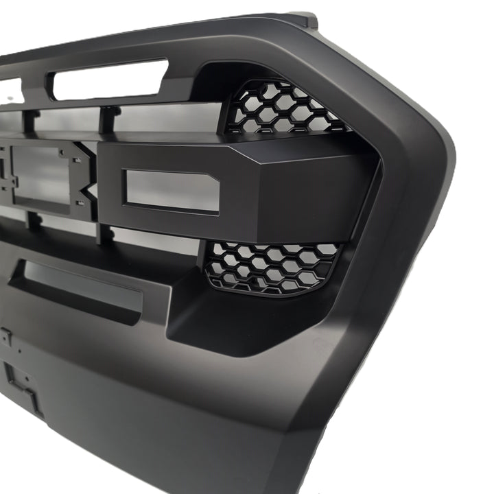 A close-up of a black heavy-duty truck grille or front bumper grille insert with honeycomb mesh details, shown on a white background.