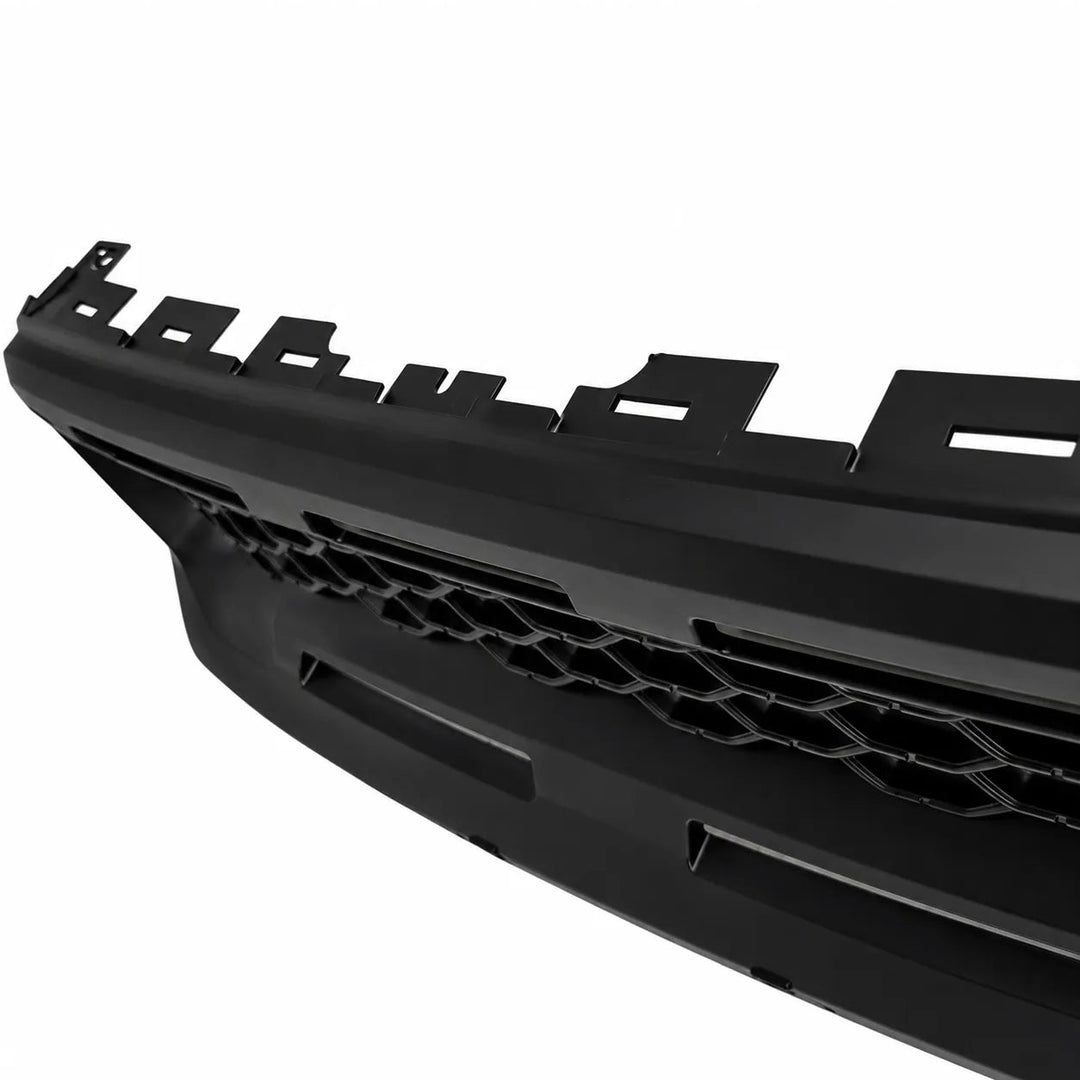 A close-up of a black automotive grille component with a honeycomb pattern and mounting tabs, shown against a plain white background.