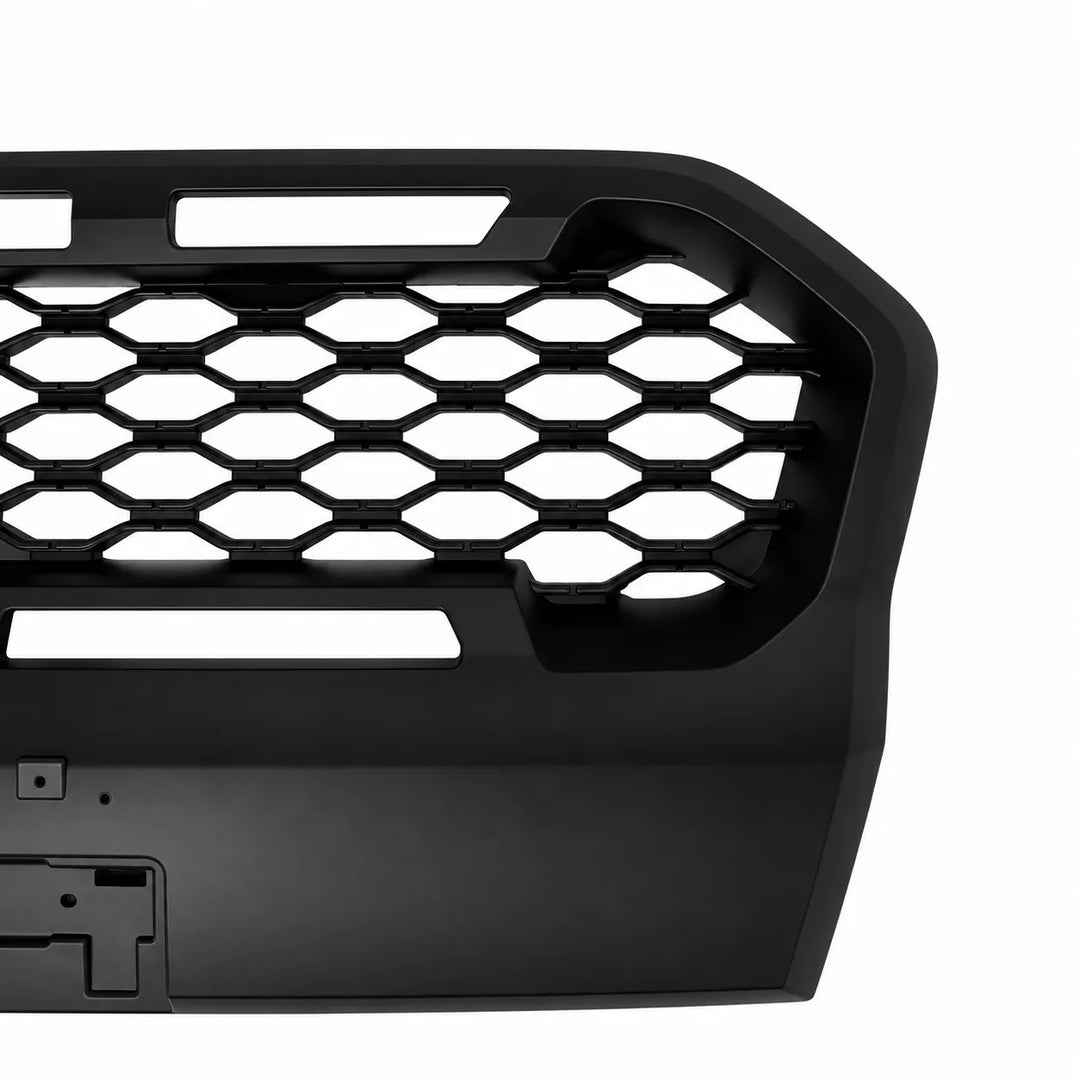 Close-up of a black vehicle front grille insert with a honeycomb pattern and cutouts, shown on a white background.