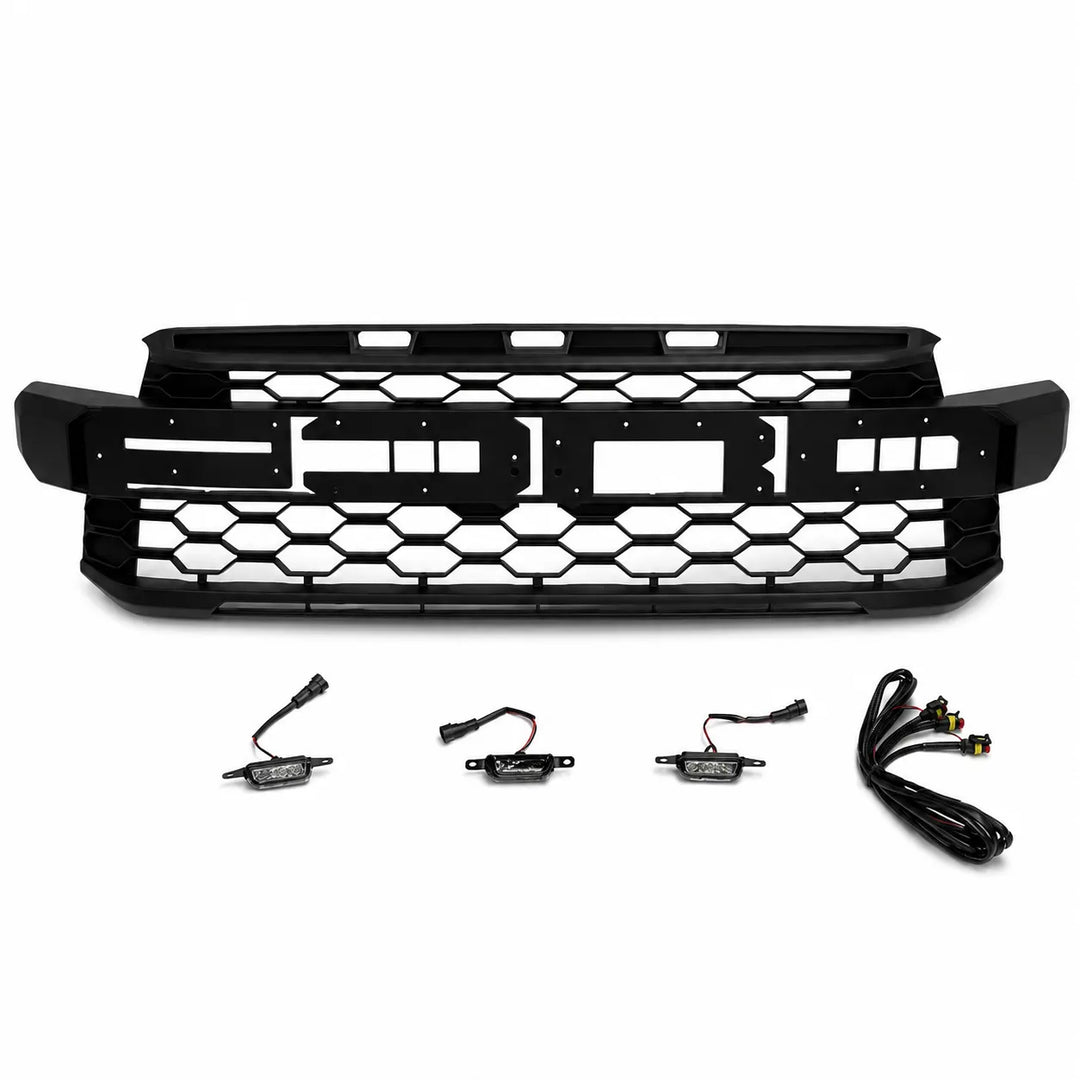 Black front grille kit with a large honeycomb-patterned grille and four small wiring harnesses, displayed on a clean white background.