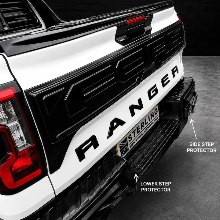 Close-up of the rear bumper area of a white Ford Ranger pickup truck showing installed black protective step guards, with callout labels pointing to the side step protector and lower step protector. Sterling branding is visible on the license plate frame.
