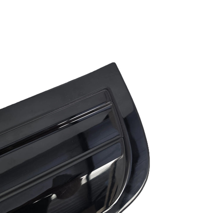 Close-up of a glossy black automotive spoiler or trim piece on a plain white background.