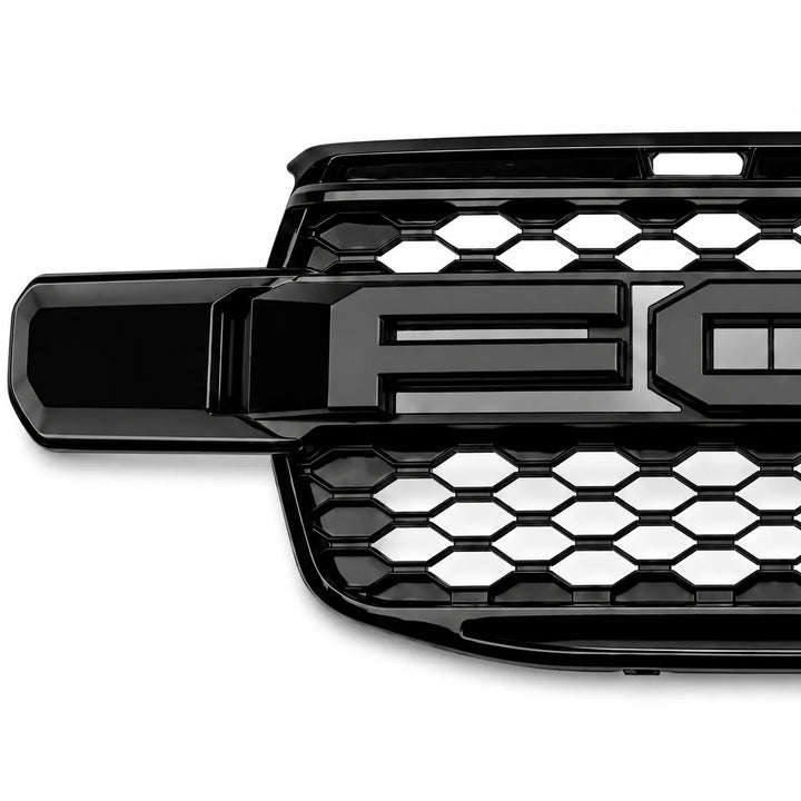 A glossy black Ford grille insert with a honeycomb pattern and a large raised 'F' emblem, shown on a white background.