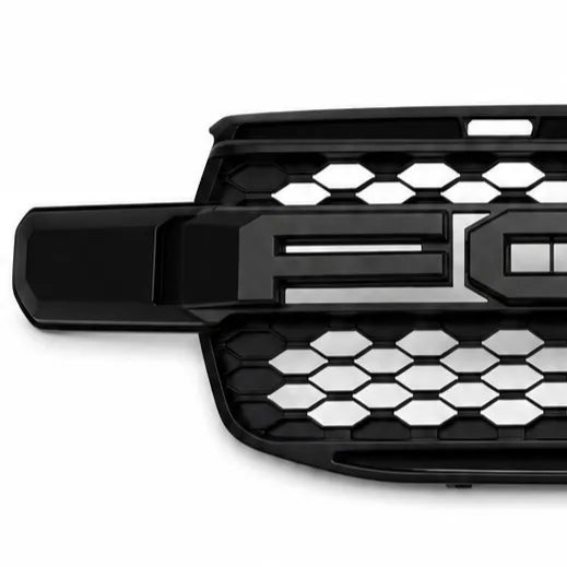 A close-up of a black vehicle grille with a honeycomb pattern and a large chrome 'FO' emblem, shown on a white background.