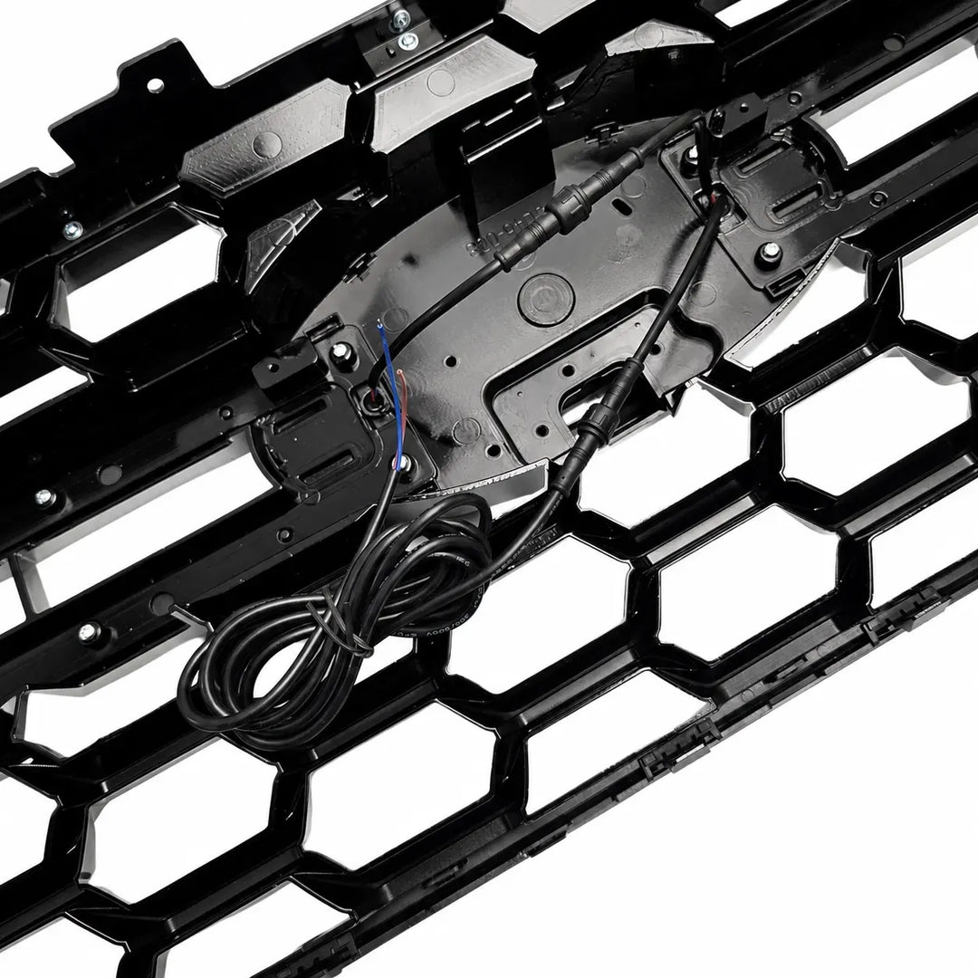 reverse shot of a Black honeycomb grille insert with integrated wiring harness and connectors, shown on a white background.