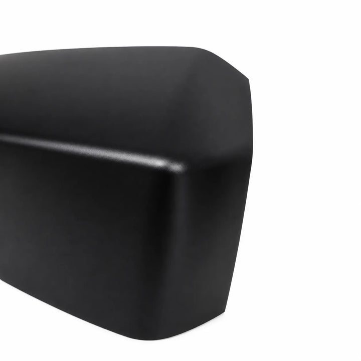 A close-up of a matte black molded plastic automotive part, a mirror cover trim piece, shown on a solid white background.