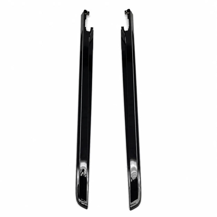 A pair of glossy black plastic and metal trim pieces, truck bed tailgate pieces, shown vertically on a plain white background.