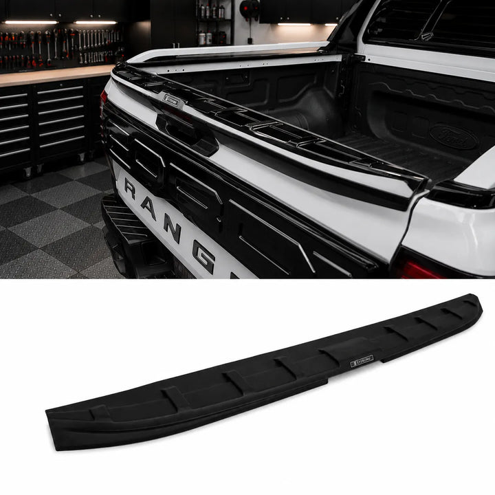 A black textured rear tailgate spoiler accessory shown in two views: installed along the rear side of a white pickup truck bed finished in gloss black, and as a standalone product finished in textured black on a white background.

