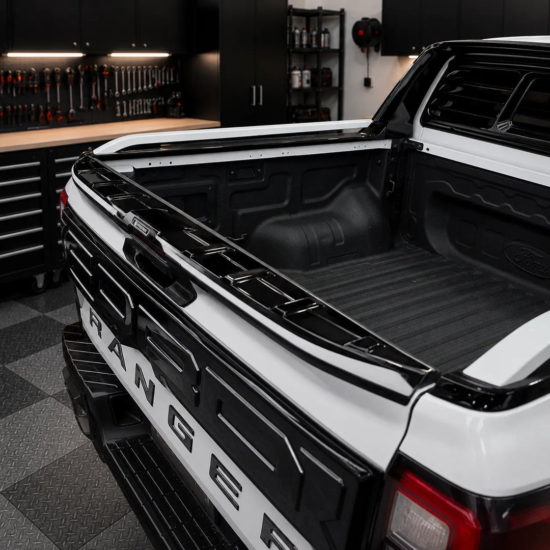 A fitted image of a gloss black plastic vehicle spoiler accessory, rear tailgate spoiler, Sterling Design Badge in the centre of our exclusive design, shown fitted to a vehicle in the sterling workshop.