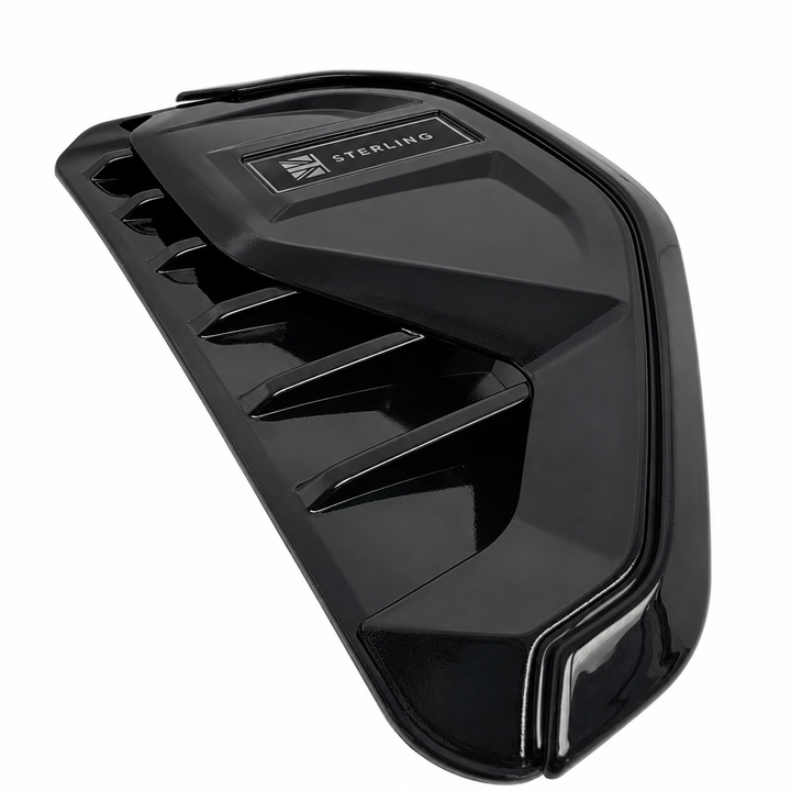 A glossy black Sterling engine intake manifold cover with a silver and black logo badge, shown on a solid white background.