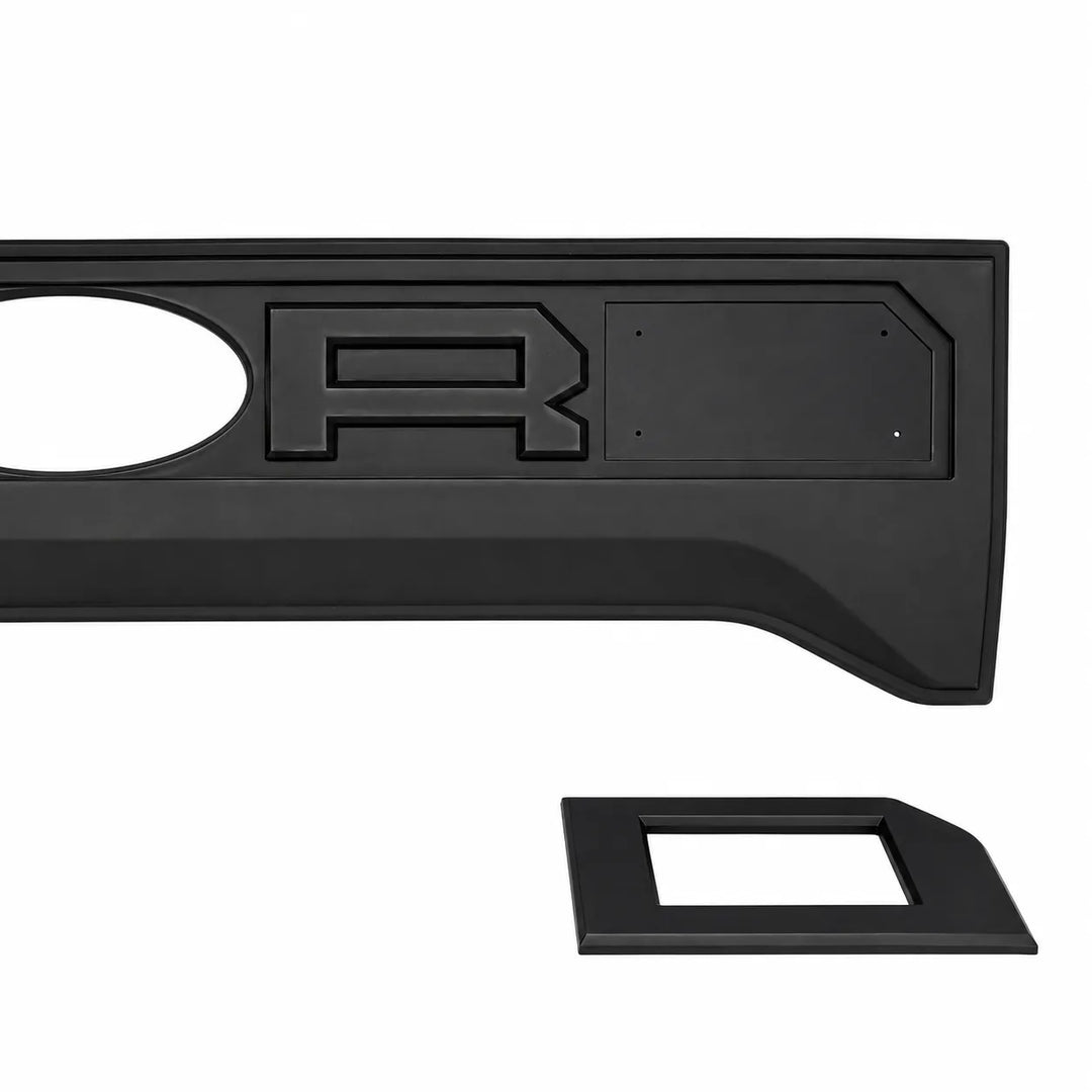 A black plastic truck bed liner insert with a raised letter 'R' emblem and a separate matching black trim piece, shown on a plain white background.