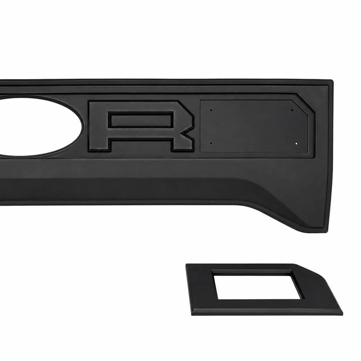 A black plastic truck bed liner insert with a raised letter 'R' emblem and a separate matching black trim piece, shown on a plain white background.