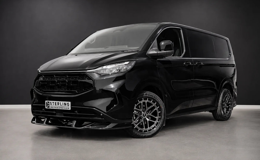 A black Sterling customized Ford Transit van with a custom front grille and lip spoiler, featuring multi-spoke dark wheels and tinted windows, photographed in a studio setting.