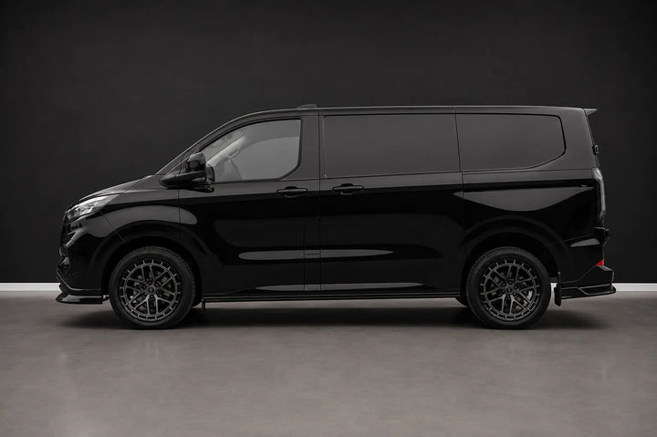 A side image of a Sterling customized Ford Transit van with a custom front grille and lip spoiler, featuring multi-spoke dark wheels and tinted windows, photographed in a studio setting.