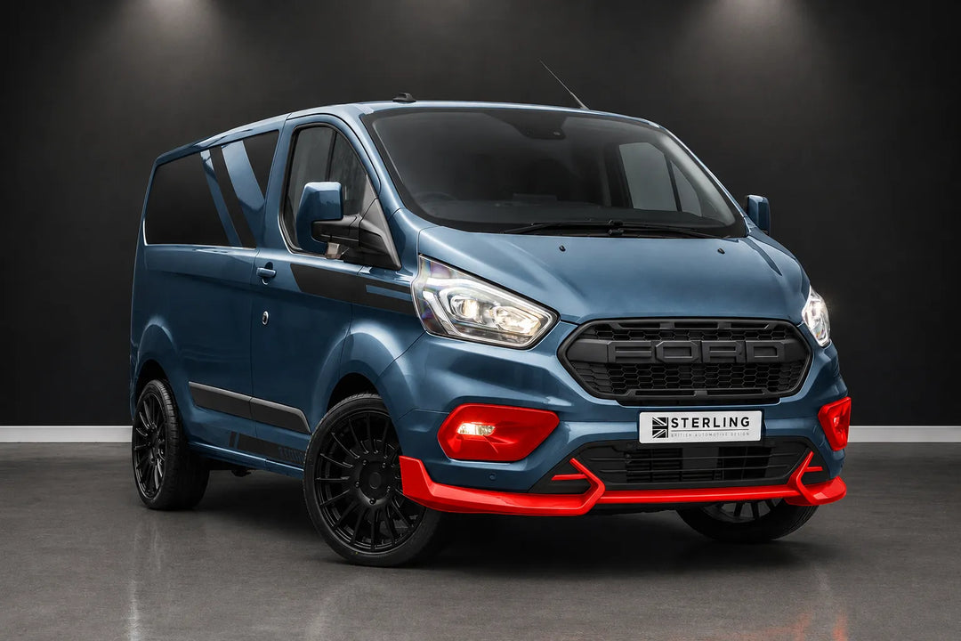 A blue Ford Transit Custom van with a custom Sterling front bumper and lip spoiler, featuring red accents and black wheels, photographed in a studio setting.